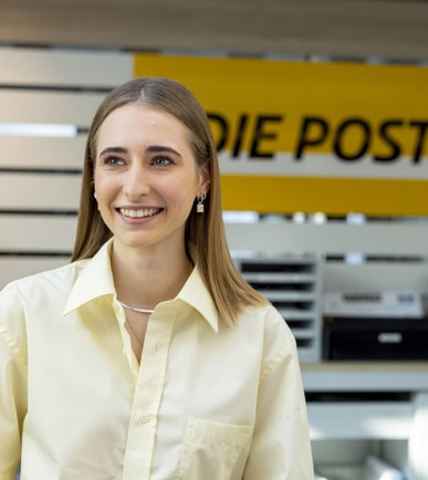 Eine junge Frau am Postschalter